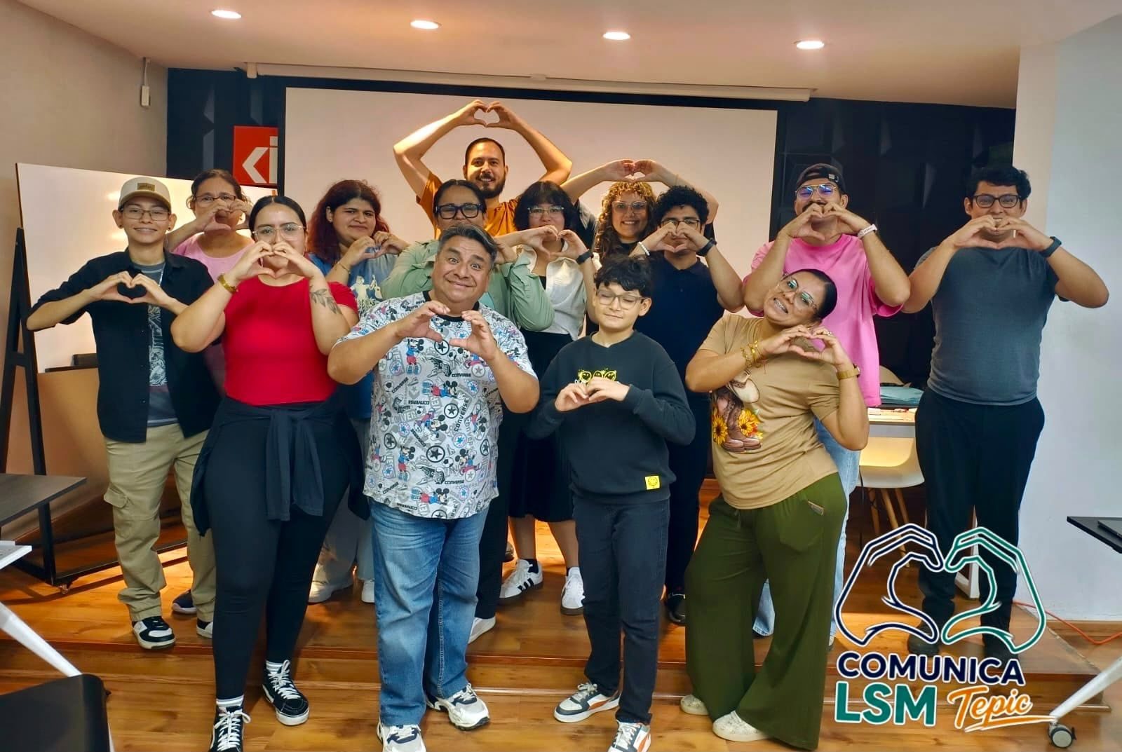 Alumnos de COMUNICA LSM haciendo la seña de corazón en el salón de clases