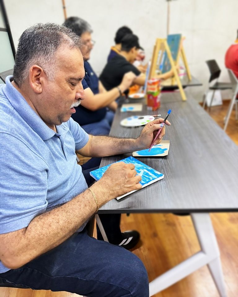 Participante concentrado pintando sobre la mesa