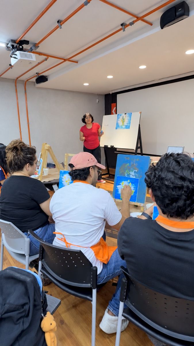 El grupo siguiendo la demostración de la maestra al frente del salón